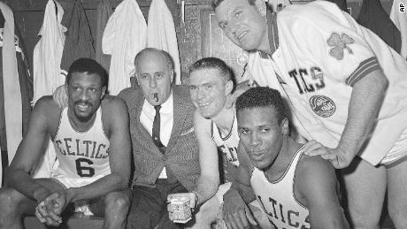 On April 9, 1964, file photo, Boston Celtics, from left, Bill Russell, Coach Reed Auerbach, Tommy Henson, Jim Lokostov, and KC Jones celebrate in the locker room after winning their eighth consecutive title in the East Section of Boston Garden in Boston. 
