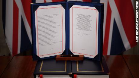 A photo shows British Prime Minister Boris Johnson signing the UK-EU Trade and Cooperation Agreement at 10 Downing Street, London, on December 30.